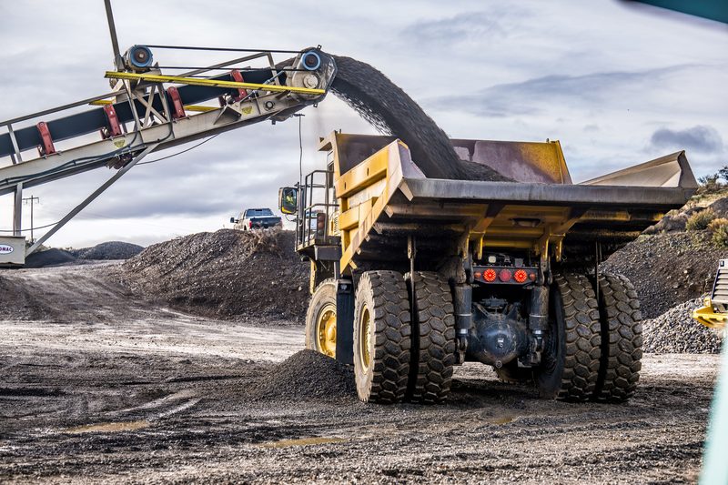 An articulated haul truck being loaded from a conveyor